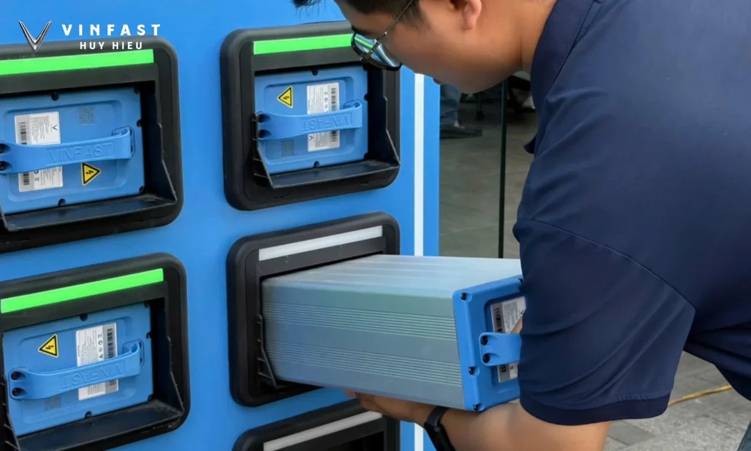 Kỹ thuật viên lắp pin vào tủ đổi pin xe máy điện VinFast